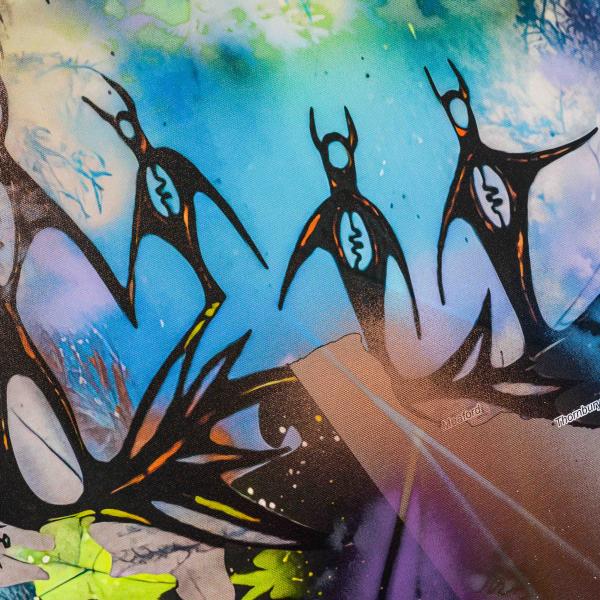 Detail shot of a canvas print featuring humanoid silhouettes against vibrant colours.