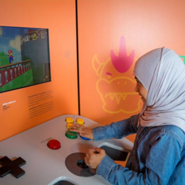A child playing Mario 64 using a giant controller